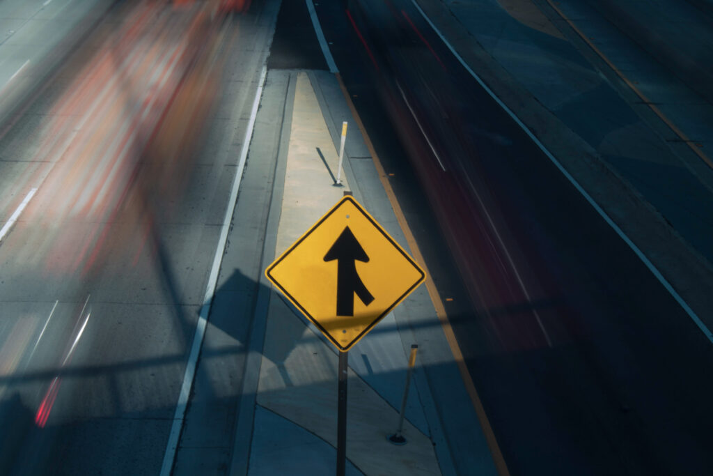 A traffic sign on a highway with blurred motion, illustrating post merger integration.