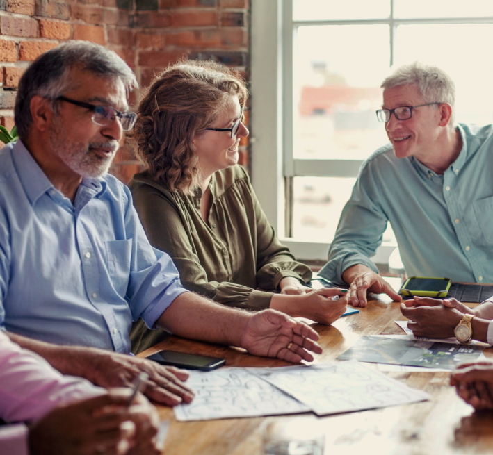 Experienced advisors in discussion with clients around table